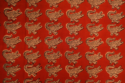 block cotton print - Brick red base with beige crocodile block print outlined in black.